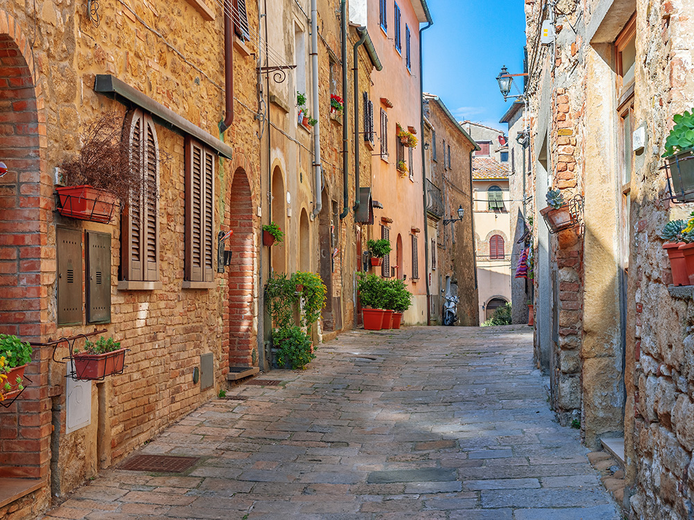 Beautiful alley lined with old brick houses in Tuscany, Old town, Italy.