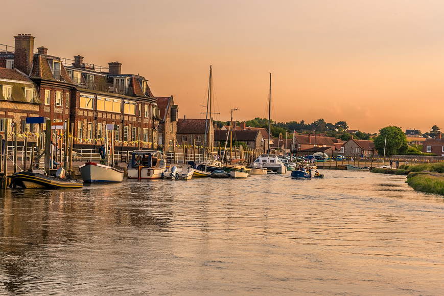 A view of the moorings on the River Glaven at sunset in Blakeney, Norfolk, UK
