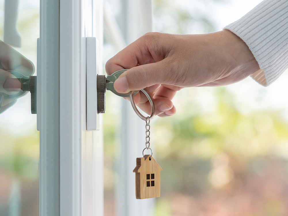 Woman holding key to home to signify house sale, which is an exit strategy of a bridging loan