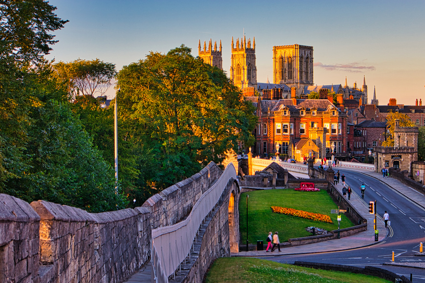 View of medieval architecture, trees and properties in York during sunset