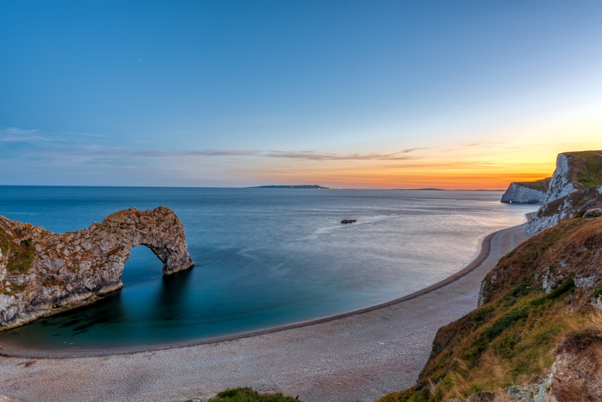 The natural arch Durdle Door at the Jurassic Coast in Dorset at sunset