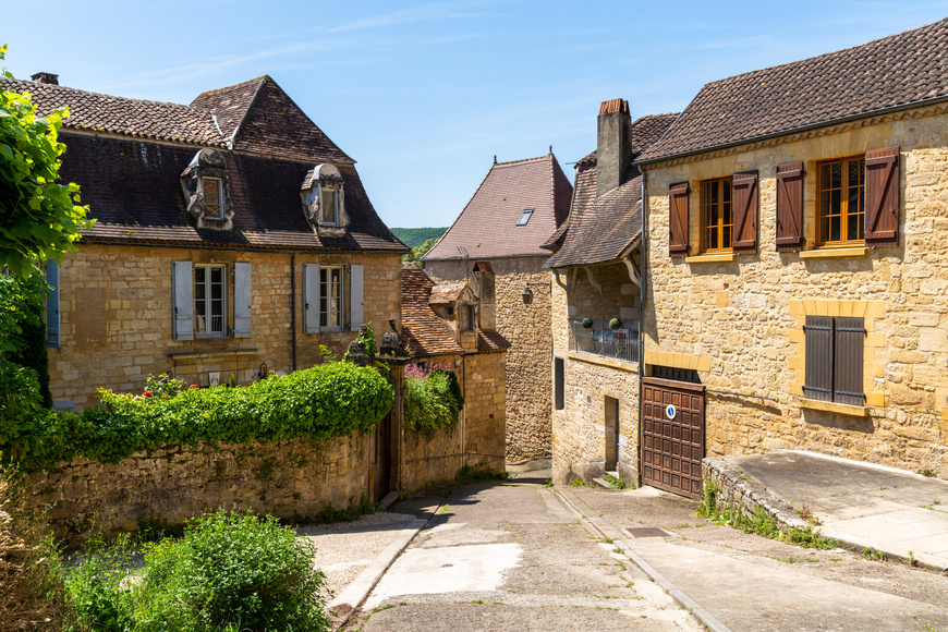 View of the historic village center of Saint-Cyprien, Dordogne, with traditional brown stone houses