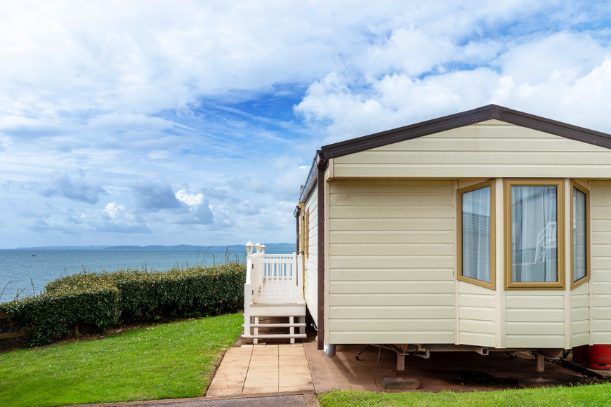 Caravan holiday park with white mobile house, view of the sea and blue sky on the coast at English seaside