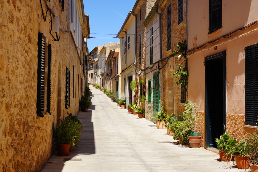 Sunny street of houses in the old town of Alcúdia, Mallorca in Spain