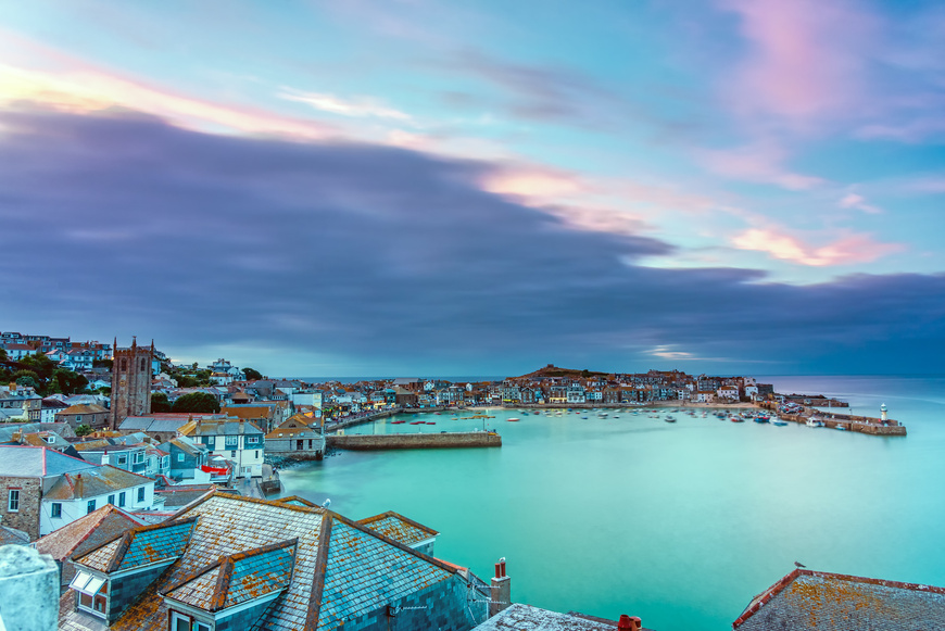 The beautiful seaside town of St. Ives in Cornwall, England, with views of the sea and properties along the coastline at dawn